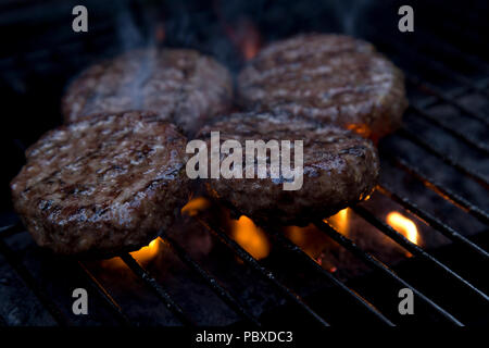 Beefburgers par cuisson sur un barbecue Banque D'Images