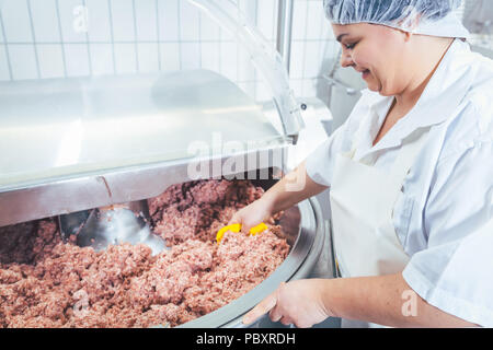 Butcher femme travaillant sur la viande de boucherie Banque D'Images