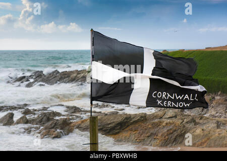 Un drapeau St Piran voltigeant dans le vent sur la côte à dans Fistral Newquay Cornwall. Banque D'Images