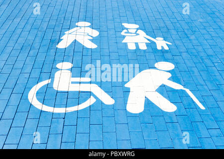 Place de stationnement pour personnes handicapées, maman avec un enfant, d'une personne âgée et l'homme de plâtre. carré bleu sur l'asphalte. Banque D'Images