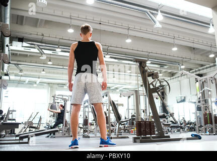 Jeune homme dans une salle de sport moderne, crossfit. Vue arrière. Banque D'Images