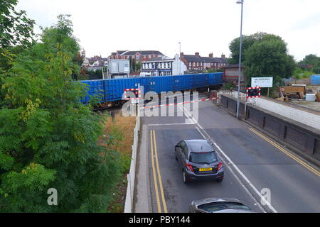 Un train de marchandises passe au-dessus d'un passage à niveau entre High Street & Albion Street à Castleford Banque D'Images