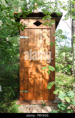 Toilettes à l'extérieur en bois dans la forêt, avec porte fermée Banque D'Images