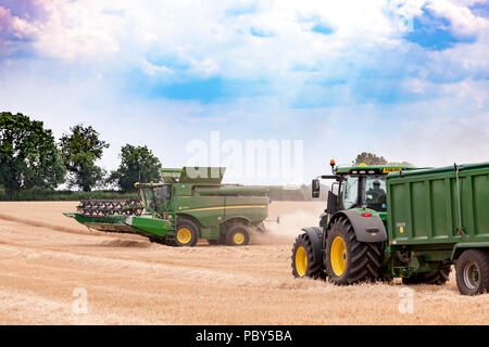 Earls Barton, Northamptonshire, Angleterre. 26 juillet, 2018. Un champ off Earls Barton Road avec un John Deere HillMaster S785i moissonneuse-batteuse, rendant le plus Banque D'Images