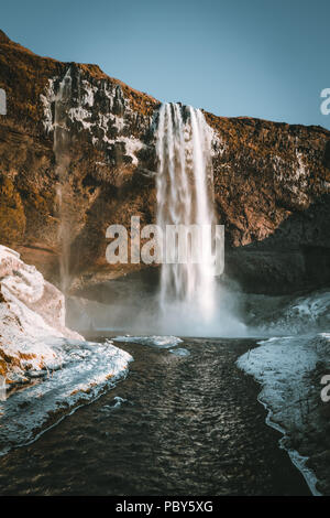 Magnifique paysage de cascade de Seljalandsfoss en Islande sur une journée claire avec ciel bleu et la neige. Banque D'Images