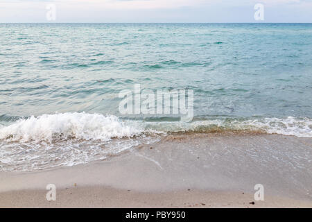 Gros plan sur la rive s'écraser des vagues à Sunny Isles Beach, North Miami, Floride, lors de soirée coucher du soleil avec de l'eau colorée, le sable humide, personne ne Banque D'Images