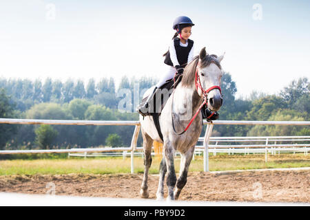 Peu gaie Chinese girl riding horse Banque D'Images