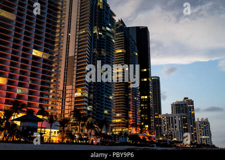 Sunny Isles Beach, appartement, condo, bâtiments de l'hôtel durant la nuit sombre soir heure bleu allumé coloré couleurs à Miami, en Floride avec des gratte-ciel Banque D'Images