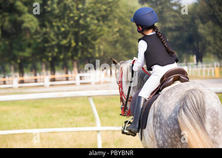 Peu gaie Chinese girl riding horse Banque D'Images