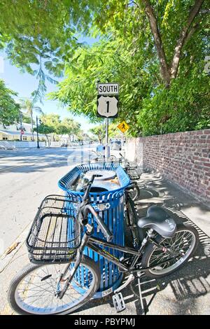 Un vélo est garé portent une corbeille sur une rue bordée d'arbres sur l'autoroute du Sud 1 à Key West en Floride Banque D'Images