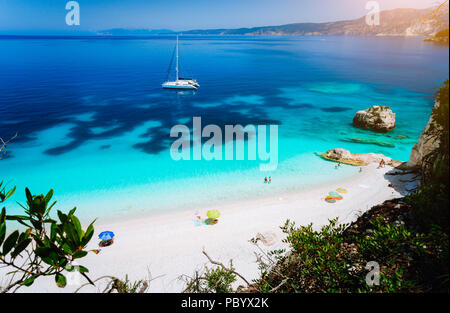 Fteri beach, île de Céphalonie Céphalonie, Grèce. Yacht à voile blanc bleu clair l'eau de mer. Les touristes sur plage de sable près de lagune azure Banque D'Images