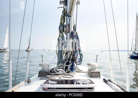 Vue depuis le pont du yacht sur le mât et le gréement, mer et bateaux dans l'arrière-plan. Banque D'Images