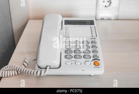 Téléphone blanc sur table dans chambre d'hôtel. Banque D'Images