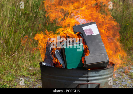 La combustion de déchets papier et carton en petit incinérateur de jardin Banque D'Images