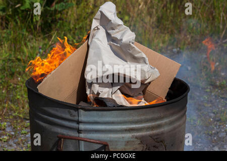 La combustion de déchets papier et carton en petit incinérateur de jardin Banque D'Images