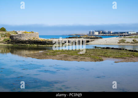 Vue sur la baie d'Cemlyn bassin de marée de passerelle et ancienne centrale nucléaire Wylfa, dans le brouillard de la mer. Cemaes, Ile d'Anglesey, au Pays de Galles, Royaume-Uni, Angleterre Banque D'Images