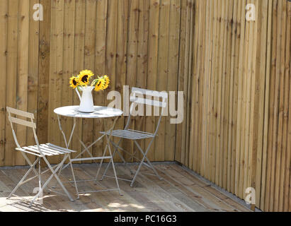 Tournesols dans un vase sur une table de jardin Banque D'Images