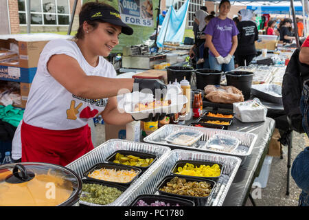 Dearborn, Michigan - une femme ajoute à une garniture à hot dog halal les smileys Halal Meats stand lors d'un rassemblement politique musulmane. La viande halal est prêt à Banque D'Images