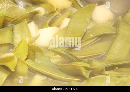 Les gousses de pois et de pommes de terre dans la soupe Banque D'Images