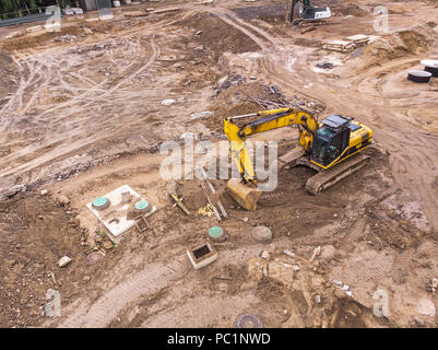 La machine excavatrice jaune travaillant dans la construction site. Vue aérienne Banque D'Images