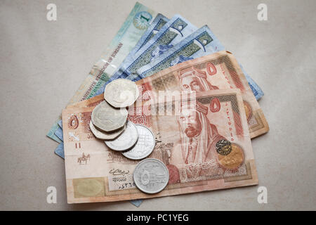 Dinars jordaniens billets et pièces piastres déposer sur du papier gris background, close-up photo Banque D'Images