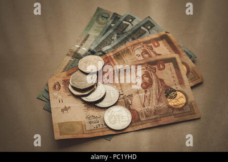 Dinars jordaniens et piastres déposer sur du papier gris background, close-up vintage photo stylisée avec effet filtre tonal Banque D'Images