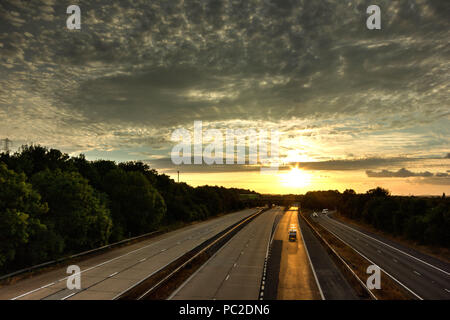 Coucher de soleil d'été avec réflexion dorée sur l'autoroute tarmac dans le Kent, Angleterre Banque D'Images