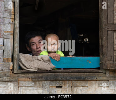 Père et fils à la fenêtre dans le Nord du Laos minorités ethniques village Banque D'Images