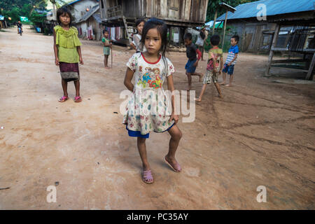 Les enfants jouent sur les rues poussiéreuses de Muang Khua, Région du Nord Laos Banque D'Images