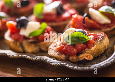 Toast Bruschetta tomates mozzarella basilic olives et huile d'olive. Ingrédients Caprese italienne et méditerranéenne ou traditionnelle. Banque D'Images