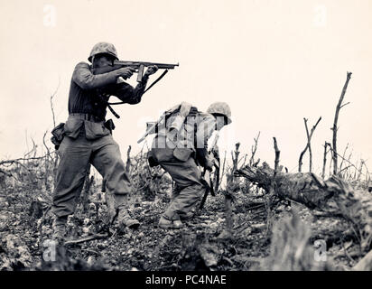 Utilise sa marine - Tommy gun- pour tuer un sniper japonais. Ces marines de la première division qui était en train de prendre la crête de Wana avant la ville de Shuri à Okinawa Banque D'Images