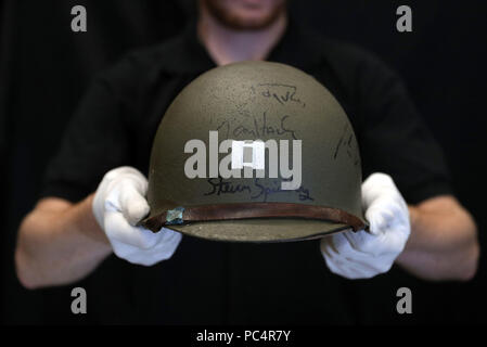De 0001 SOUS EMBARGO MERCREDI 1 AOÛT UN Prop Store employé détient un casque porté par Tom Hanks dans Il faut sauver le soldat Ryan, signée par Tom Hanks et Steven Spielberg (estimation (&pound;10-15000), dans la Prop Store siège social près de Rickmansworth avant la vente aux enchères des souvenirs de divertissement le 20 septembre. Banque D'Images