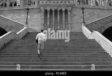 L'homme en montant les escaliers du Bastion des Pêcheurs à Budapest alors qu'un homme est la peinture à l'arrière-plan Banque D'Images