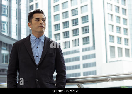 Businessman standing on walkway of building Banque D'Images