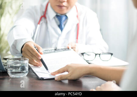 Signature du patient médecin introduit sur les dossiers médicaux avant de traiter la maladie dans hospitalmm, concept sain Banque D'Images