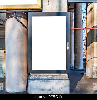 Un grand panneau blanc attaché à un mur de briques à l'intérieur avec plancher en bois Banque D'Images