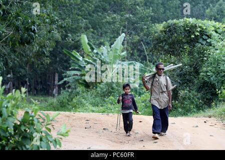 Père et fils sur un chemin. Kon Tum. Le Vietnam. Dans le monde d'utilisation | Banque D'Images