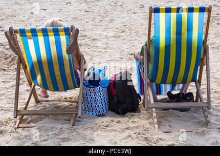 Bournemouth, Dorset, UK. Le 31 juillet 2018. Météo France : le soleil revient et les températures s'élèvent comme les amateurs de plages à la tête de la mer pour profiter du temps chaud et ensoleillé. couple assis sur des chaises longues sur la plage - arrière vue arrière. Credit : Carolyn Jenkins/Alamy Live News Banque D'Images