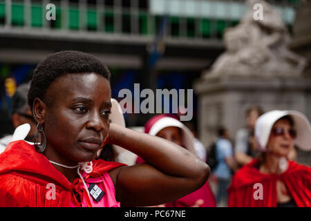 New York, USA., 31 juillet 2018 militant de l'Immigration Thérèse Patricia Okoumou parle de manifestants devant la U.S. Custom House, où le Vice-président Mike Pence a assisté à un sommet de la cybersécurité. Okoumou, un natif du Congo, a été arrêté le 4 juillet 2018, après l'ascension de la base de la Statue de la liberté, pour protester contre la séparation des enfants des parents à la frontière. Au cours de la manifestation de mardi environ deux douzaines de femmes vêtus de manteaux rouges et bonnets inspiré par l'émission de télévision et du livre "La Servante écarlate" a protesté en faveur des droits des femmes. Crédit : Joseph Reid/Alamy Live News Banque D'Images