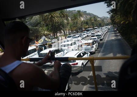 Malaga, Malaga, Espagne. 1er août 2018. Un touriste observe les chauffeurs de taxi de bloquer la route principale dans un bus touristique.une protestation à l'appui de la grève des chauffeurs de taxi contre la concurrence déloyale par les entreprises avec les transports privés Uber et Cabify. Credit : Jésus Merida/SOPA Images/ZUMA/Alamy Fil Live News Banque D'Images