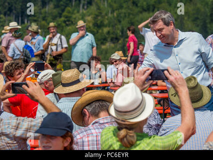 Hausham, Allemagne. 06Th Aug 2018. Markus Soeder (R) de l'Union chrétienne sociale (CSU), Premier Ministre de Bavière, accueille les participants de la Grande Chaumière alpine ascension dans le Kreuzbergalm beer garden. En raison de la persistance de la chaleur, cette année, moins de personnes ont pris part à l'assemblée annuelle de l'inspection principale de l'alpage alpage management association. Credit : Lino Mirgeler/dpa/Alamy Live News Banque D'Images