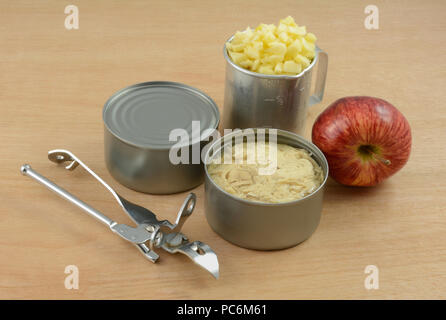 Les boîtes de conserve de thon blanc, poisson ouvre-boîte rétro, la pomme Red Delicious et haché apple en retro vintage ouvre-boîtes pour faire simple salade de thon Banque D'Images