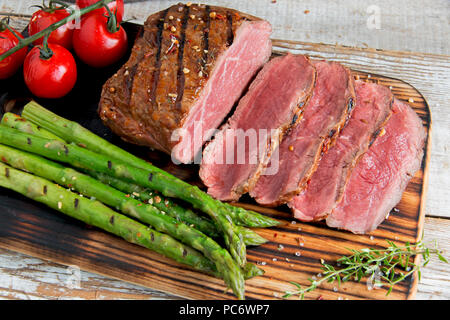 Grillades de viandes fraîches de boeuf grillé.trancheuse saignante , les asperges, tomates Banque D'Images