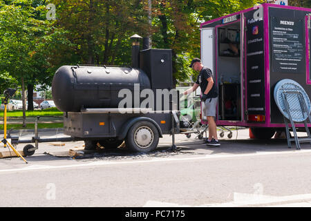 Ploiesti, Roumanie - 14 juillet 2018 : l'homme assiste à un barbecue / four en forme de locomotive à la Fête médiévale qui a eu lieu à Ploiesti, Prahova, romani Banque D'Images