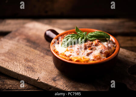 Lasagne traditionnelle dans une cocotte sur table en bois Banque D'Images