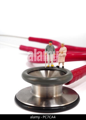 Couple miniature, de petites figures, debout sur stéthoscope. Soins de santé et mode de vie sain concept. Banque D'Images