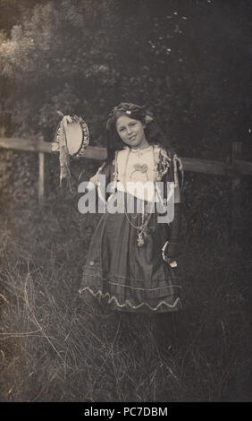 Vintage 1912 Photo d'une jeune fille nommée comme Nora Squires habillés en costume tenant un tambourin Banque D'Images