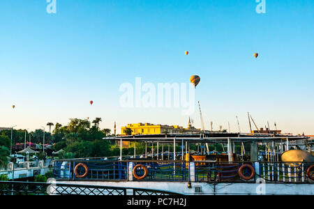Ballons à air chaud de plus en plus tôt le matin au-dessus de bateaux de croisière touristique, Nil, Luxor, Egypte, Afrique du Sud Banque D'Images