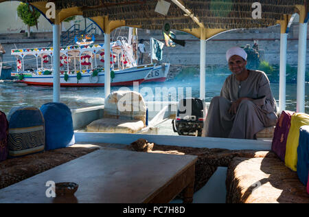 Smiling ancien Egyptien locales traditionnelles en robe et turban avec moteur hors-bord d'ferry pour traverser la rivière du Nil à Louxor, Égypte, Afrique Banque D'Images