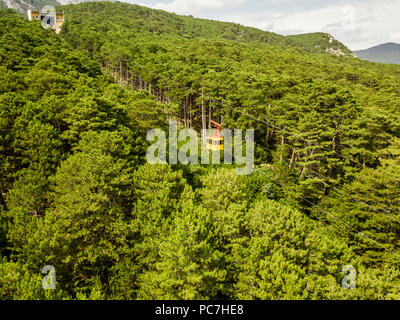Cabine téléphérique vue aérienne déménagement sur la forêt arbres et le transport des passagers à l'intérieur de la route avec Banque D'Images